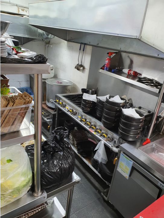Observation of a commercial kitchen environment, examining cooking equipment, ingredients, and layou